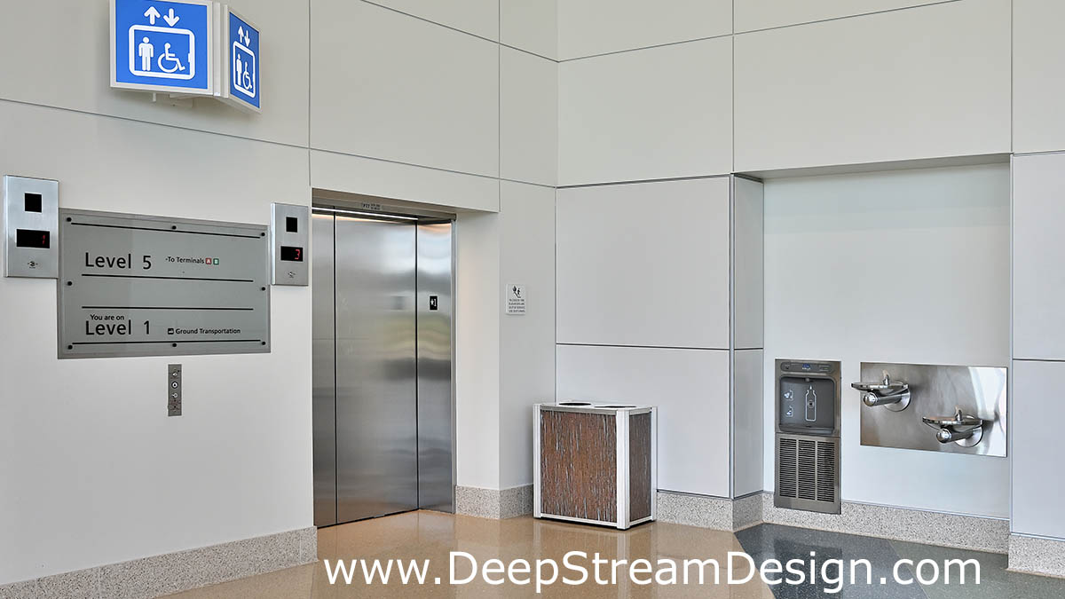 DeepStream modern combination recycling receptacle and trash bin with 3form Varia Thatch resin panels in the Virgin Atlantic train elevator lobby and restroom entrance with drinking fountain