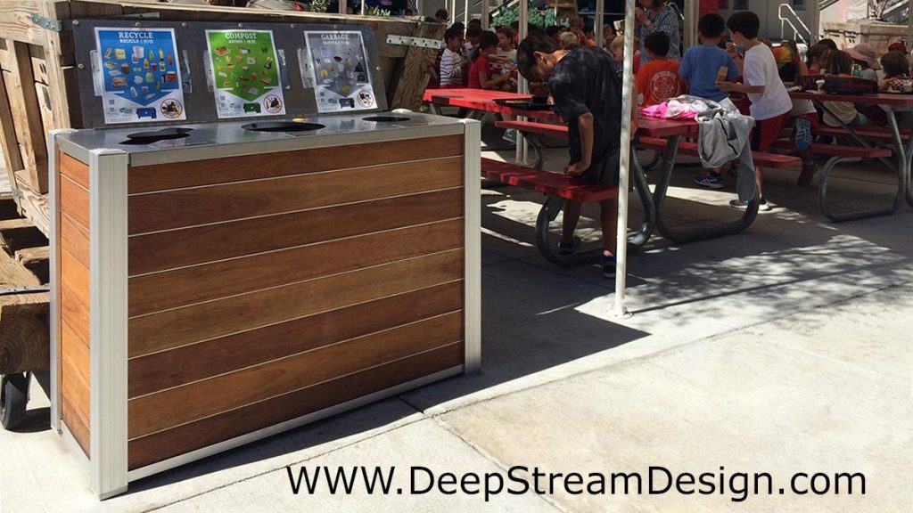 DeepStream modern wood multi stream recycling bin with open weatherproof cover open outside at a school
